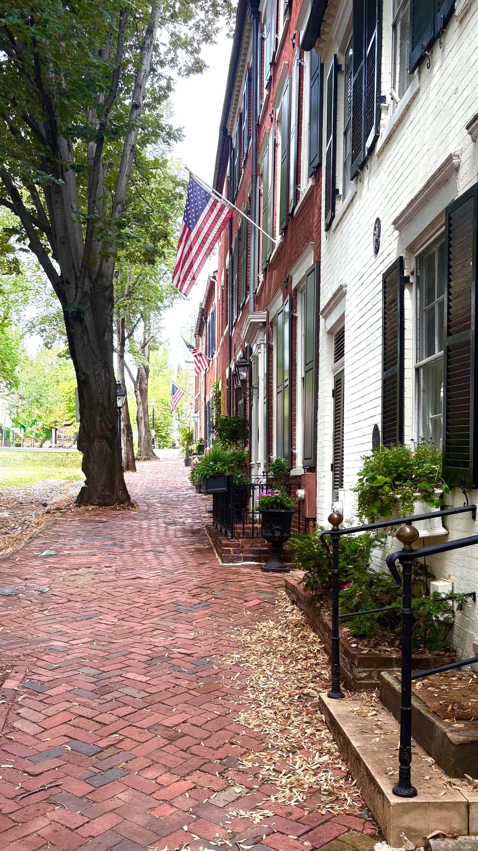A flag-lined brick walkway past Old Town Alexandria rowhouses, an inviting first step toward a conversation