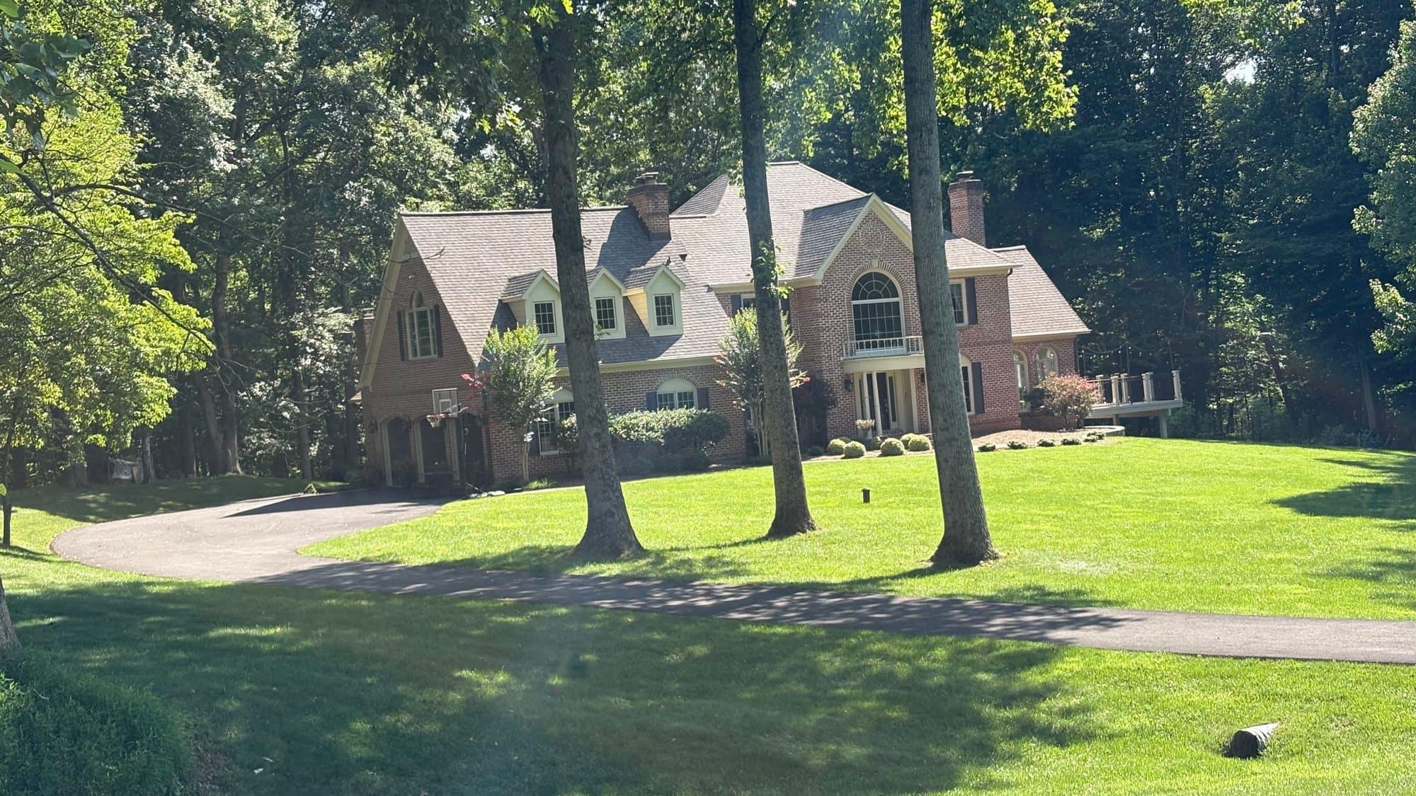 A brick Fairfax Station home nearly enclosed by mature trees on a large, wooded private lot